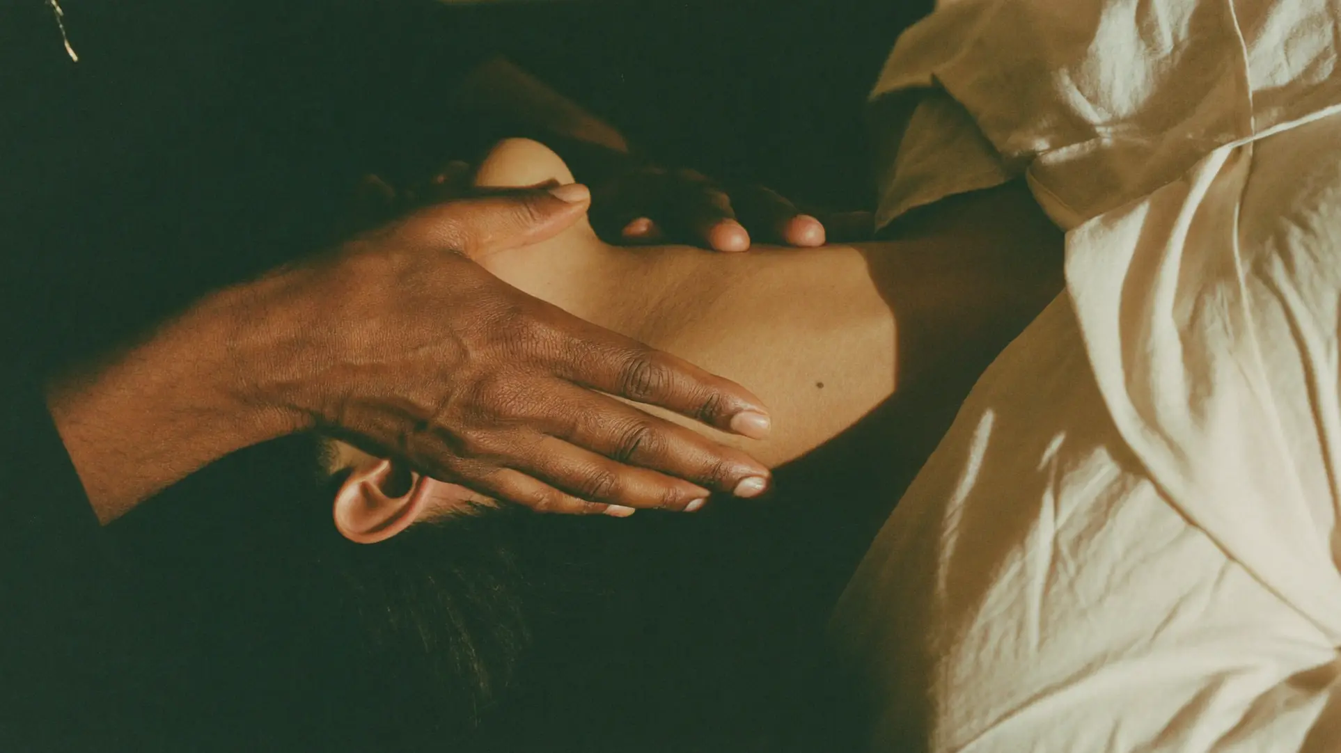 A practitioner's hands in one continuous stroke from décolleté toward the jawline