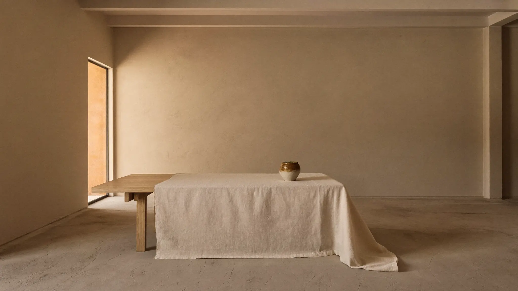 Warm plaster treatment room with a linen-draped table in soft morning light